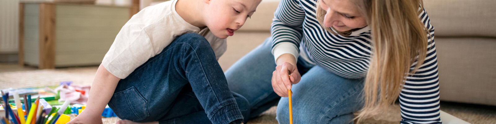 Mother and son drawing whilst sitting on the floor